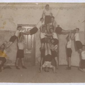 Grupa mężczyzn podczas ćwiczeń gimnastycznych na sali gimnastycznej
